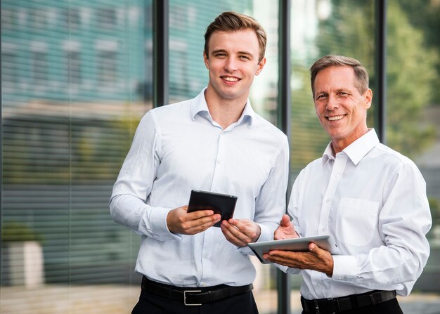 Businessmen with tablets looking at camera