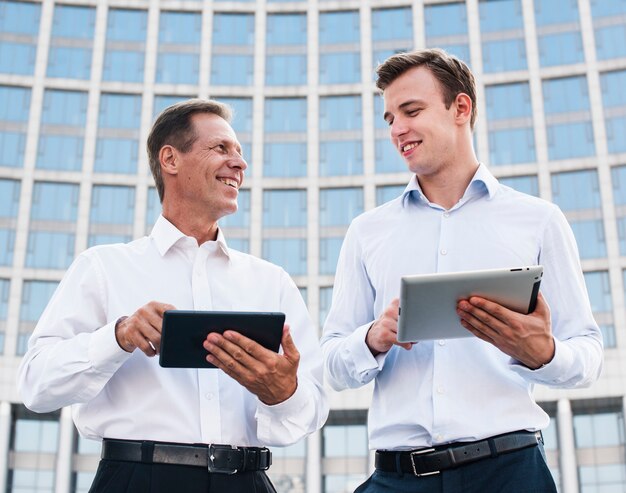 Businessmen with tablets looking at each other