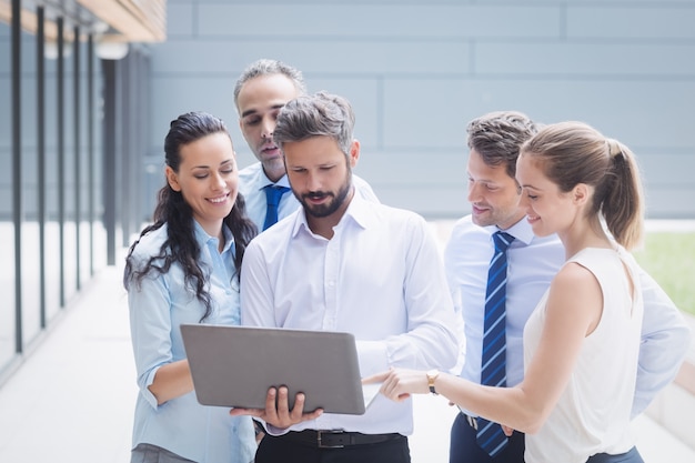 Businesspeople discussing over laptop