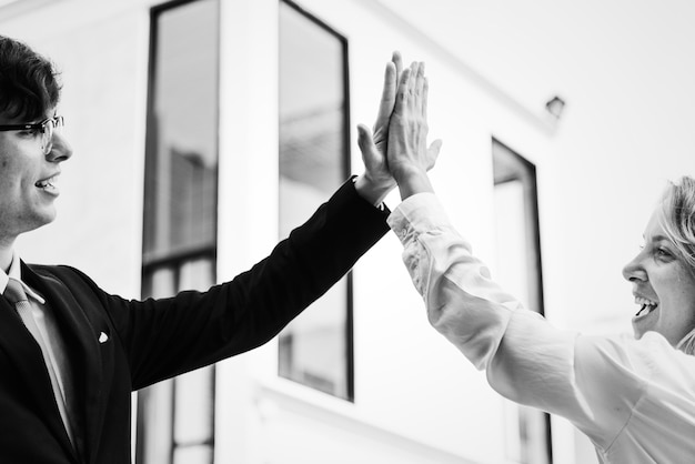 Free photo businesspeople giving a high five together