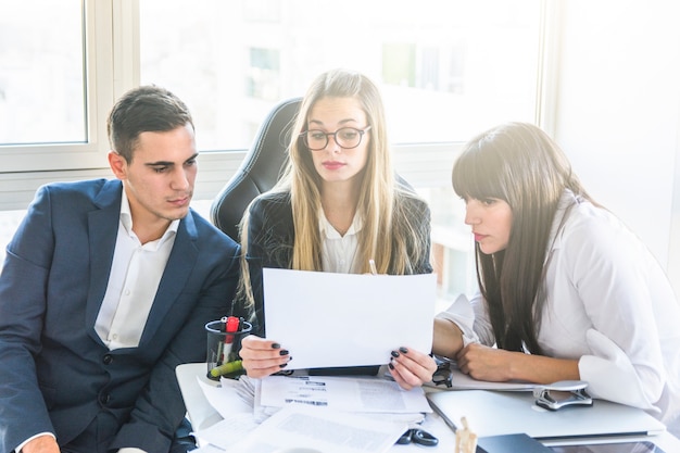 Businesspeople looking at document in office