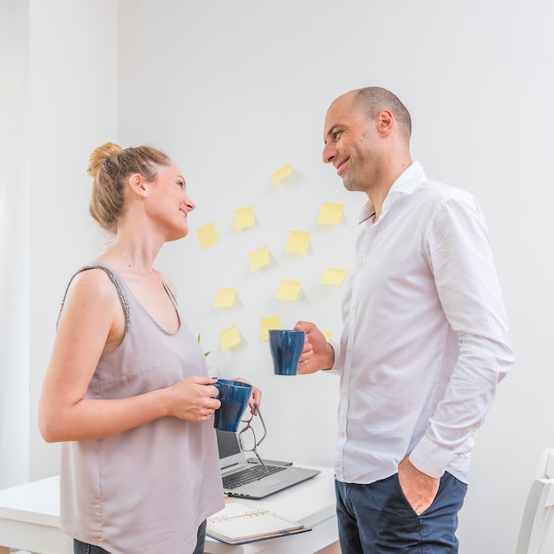 Free Photo businesspeople looking at each other while holding cup of coffee