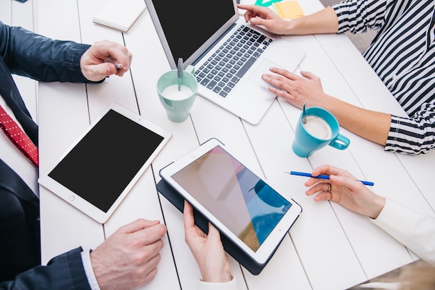 Free photo businesspeople with devices at table