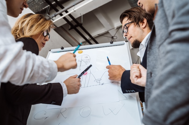 Free photo businesspeople with whiteboard discussing strategy in a meeting