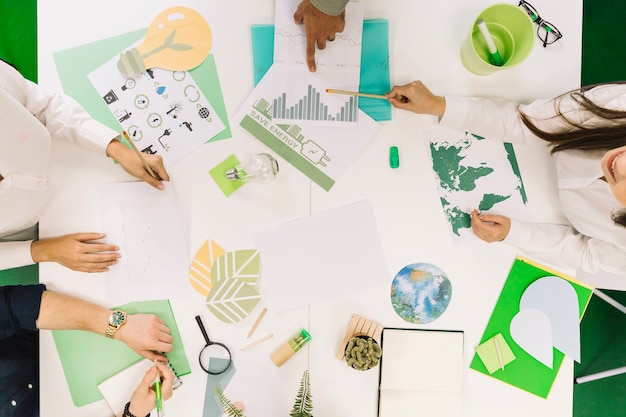 Free Photo businesspeople working on graph with various natural resources icon on desk