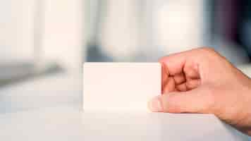 Free photo businessperson's hand holding blank white card