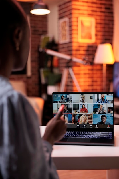 Free photo businesswoman chatting with remote team on teleconference using laptop, back view. company colleagues discussing business on videocall, office employees teamwork and cooperation