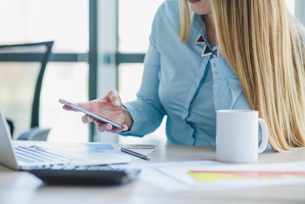 Free Photo businesswoman checking smartphone close up