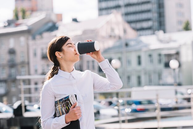 Businesswoman drinking coffee outdoors