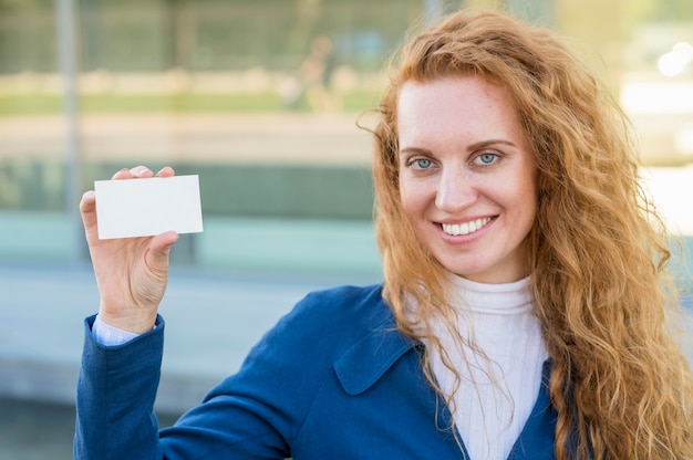 Businesswoman holding a business card and smiles