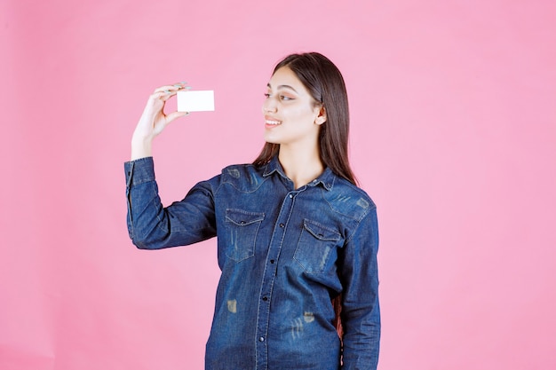 Businesswoman holding and looking at her business card