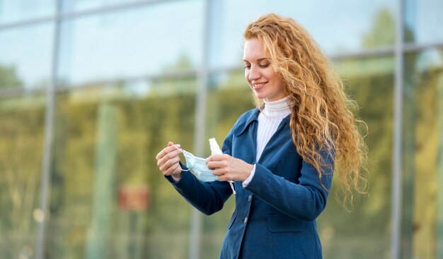 Businesswoman holding a medical mask