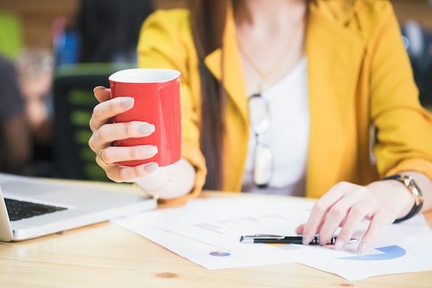 Free photo businesswoman holding red cup of coffee on coffeebreak time.