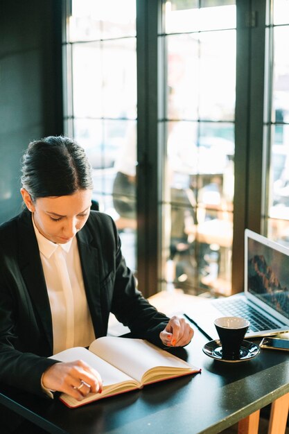 Businesswoman looking in diary over desk