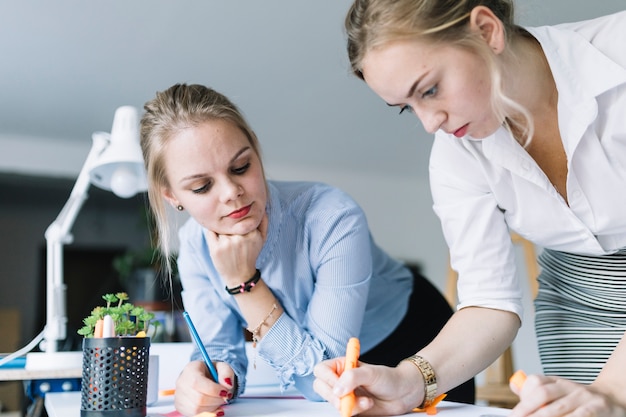 Free Photo businesswoman looking at her colleague drawing the chart in the office