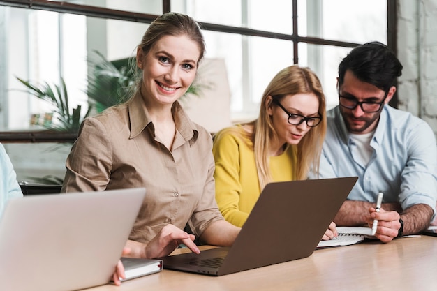 Businesswoman posing during a meeting indoors with laptop