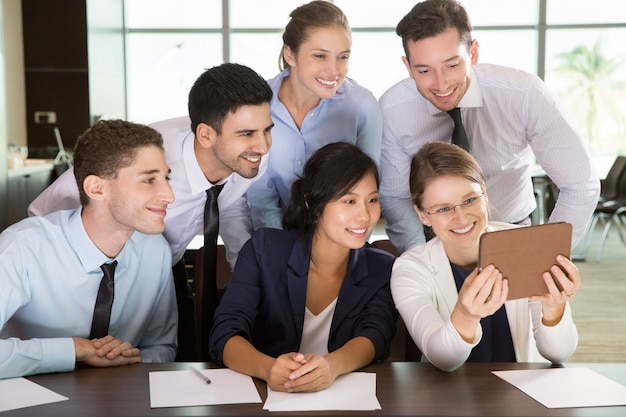 Businesswoman Showing Tablet PC to Team