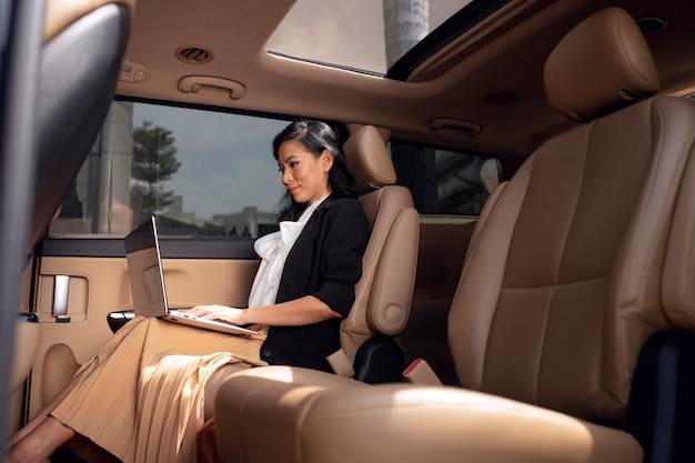 Free photo businesswoman sitting in the backseat of a taxi