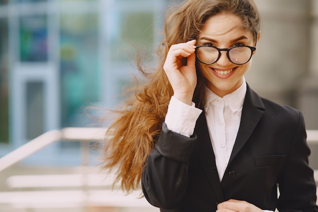 Free Photo businesswoman standing outdoors in city office building 