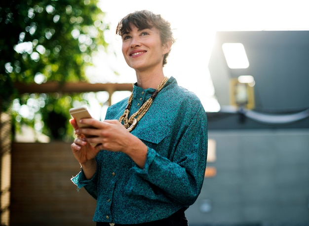 Free photo businesswoman standing and using mobile phone