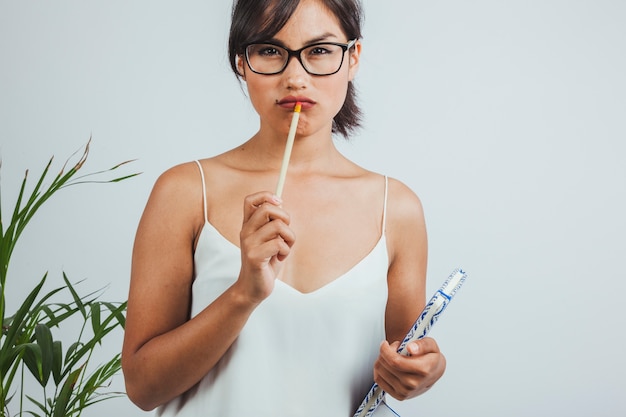 Businesswoman thinking with a pencil on her lips