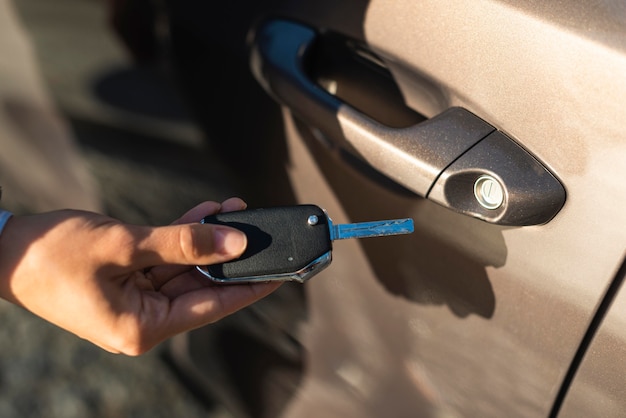 Businesswoman using the key to unlock her car door