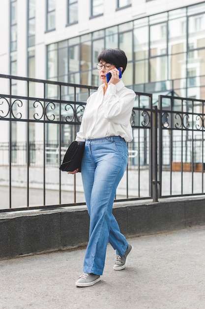 Businesswoman walking next to a big building