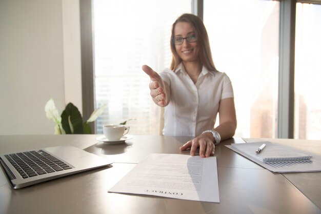 Businesswoman with contract reaching out her hand