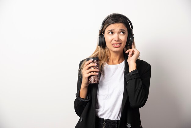 Businesswoman with cup and headphones . 