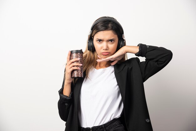 Businesswoman with cup and headphones . 