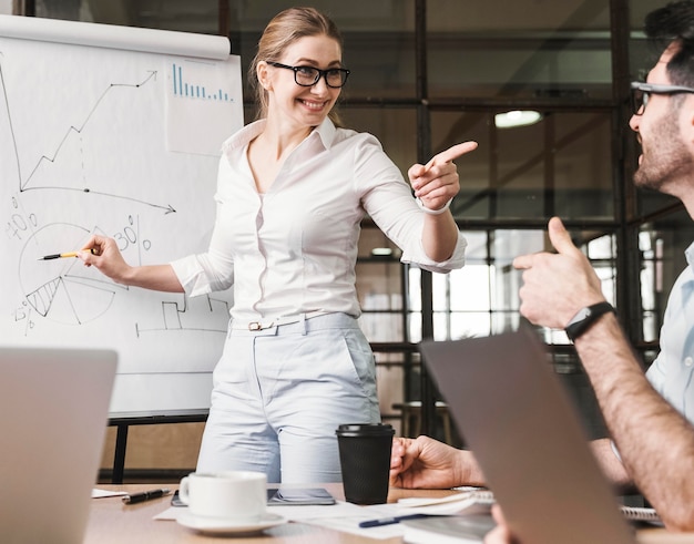 Free photo businesswoman with glasses during a meeting presentation with her coworkers