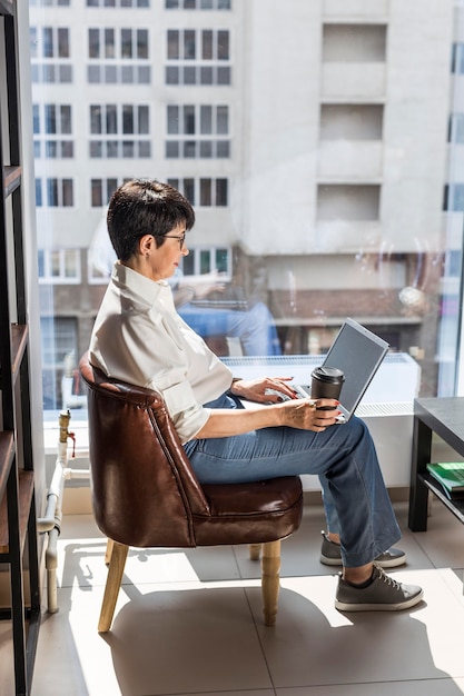 Free Photo businesswoman with laptop and coffee