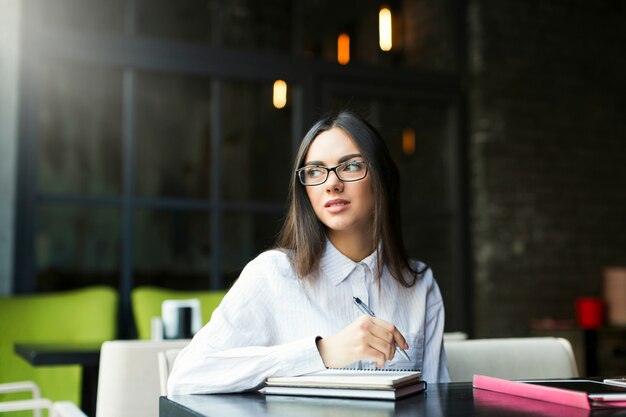 Businesswoman with notepad in cafe