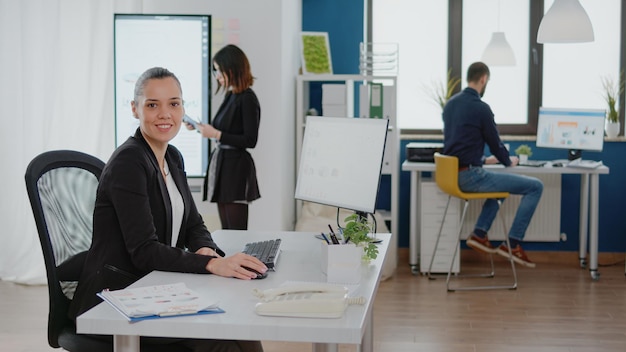 Businesswoman working on computer with data charts for management strategy in corporate office. Entrepreneur using technology and monitor for research analysis and design planning.