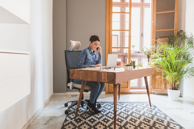 Businesswoman working while talking on the phone