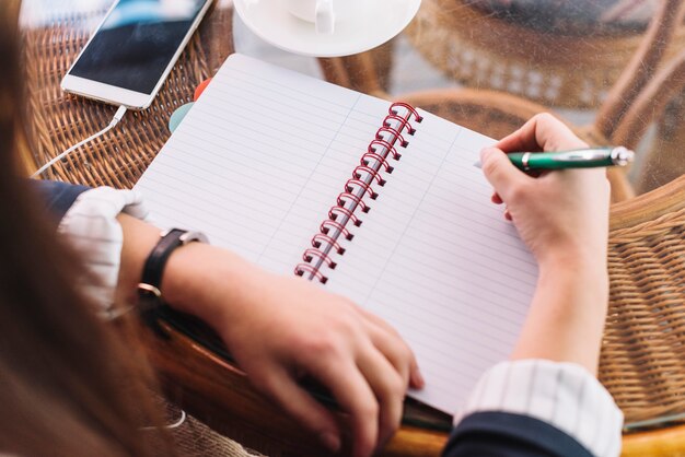 Businesswoman writing in coffee shop