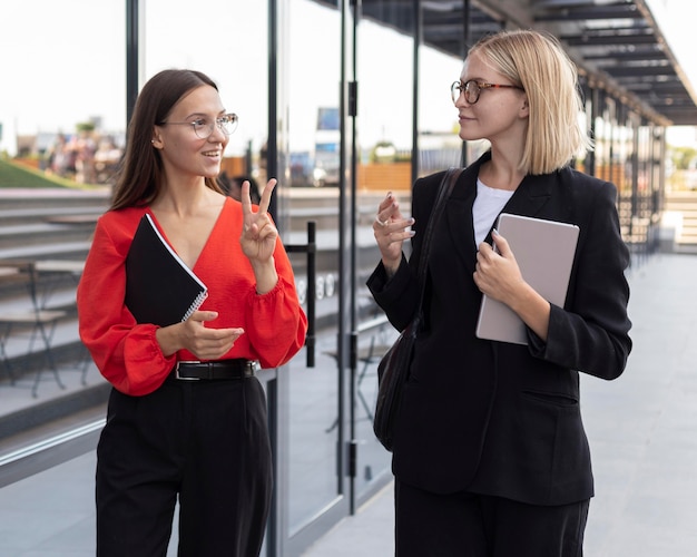 Businesswomen using sign language outside