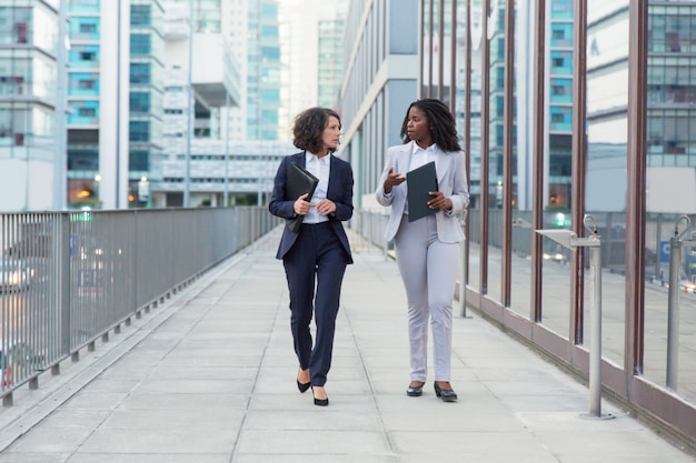 Businesswomen walking and talking on street