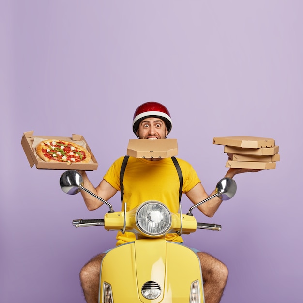 Free Photo busy deliveryman driving yellow scooter while holding pizza boxes