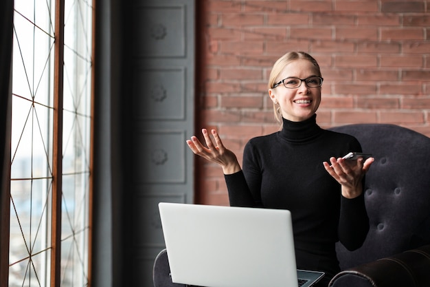 Free Photo busy woman with laptop and phone