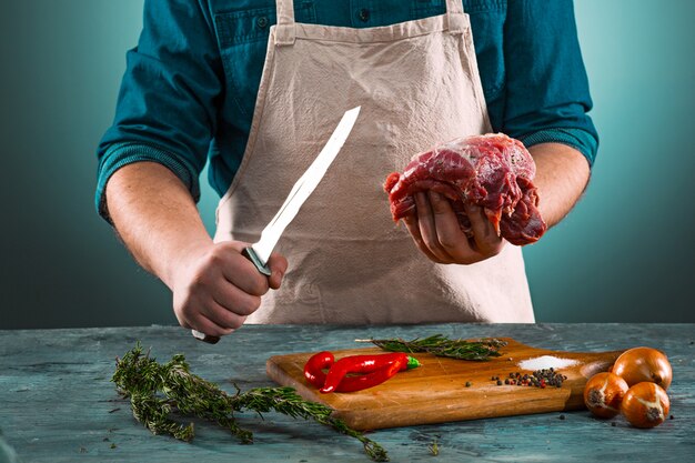 Butcher cutting pork meat on kitchen