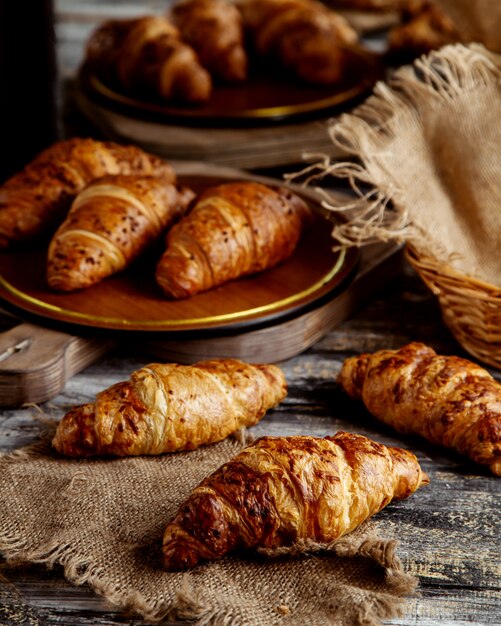 Butter croissants places on linen fabric and straw baskets