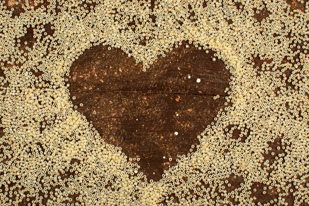 Buttons yellow surrounding heart shape on a wooden rustic brown floor