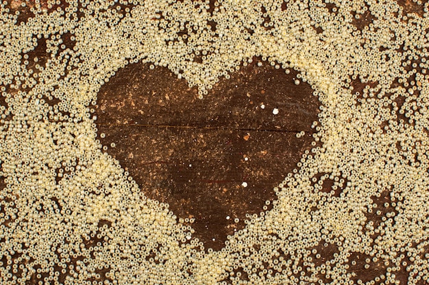 Buttons yellow surrounding heart shape on a wooden rustic brown floor