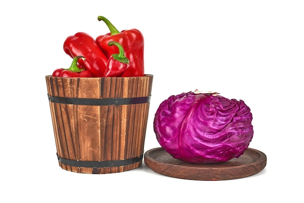 Free Photo cabbage on a wooden platter and peppers in a bucket.