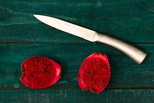 Free Photo cactus fruit halved on table with wooden background