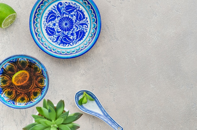 Free Photo cactus plant; lemon and mint tea cup in oriental floral design on textured backdrop