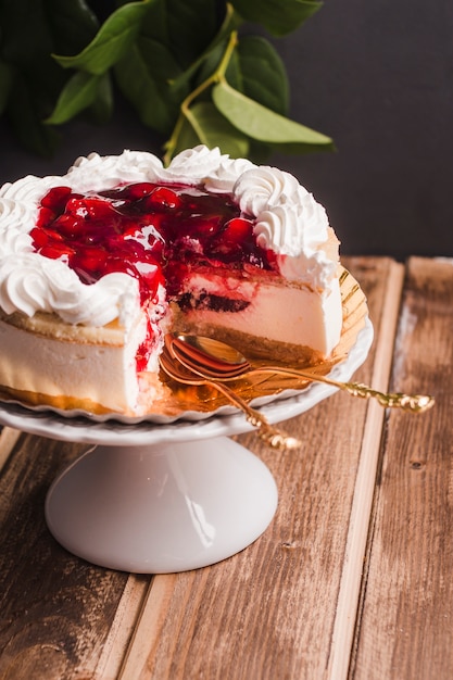 Cake with cherry jam on wooden table