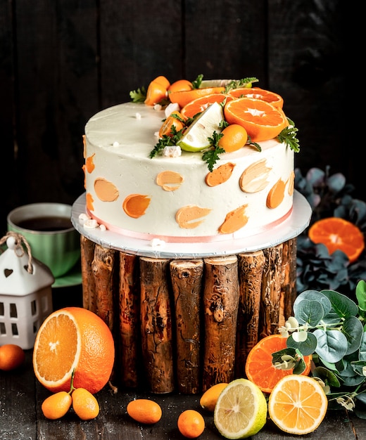 Free photo cake with white cream decorated with lime and orange