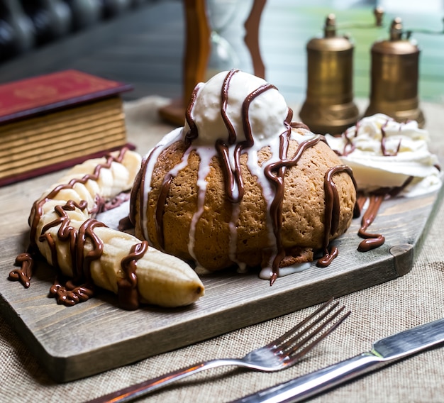 Free photo cake on wooden board with banana cream chocolate side view